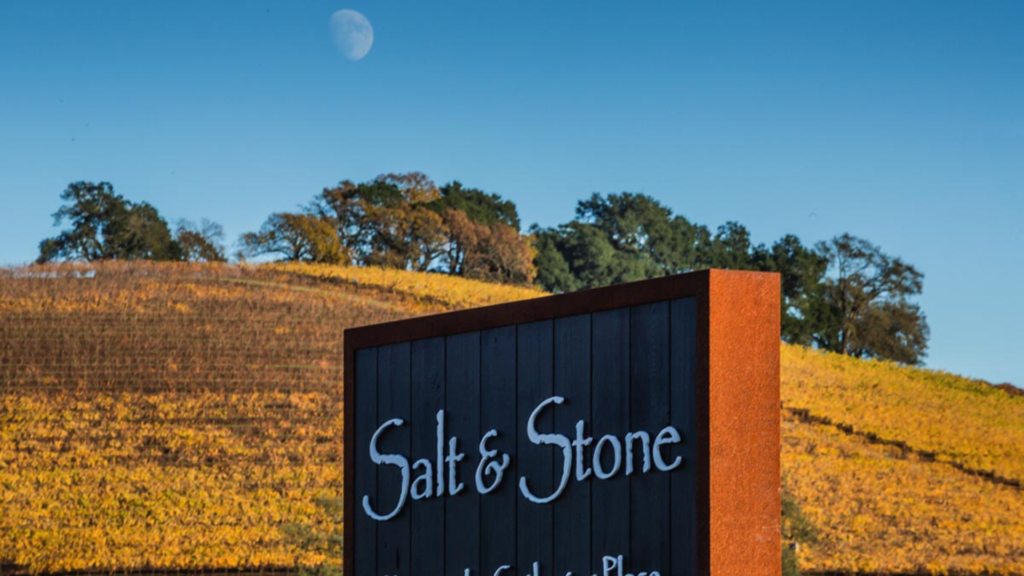 salt and stone sign with vineyard and moon in background