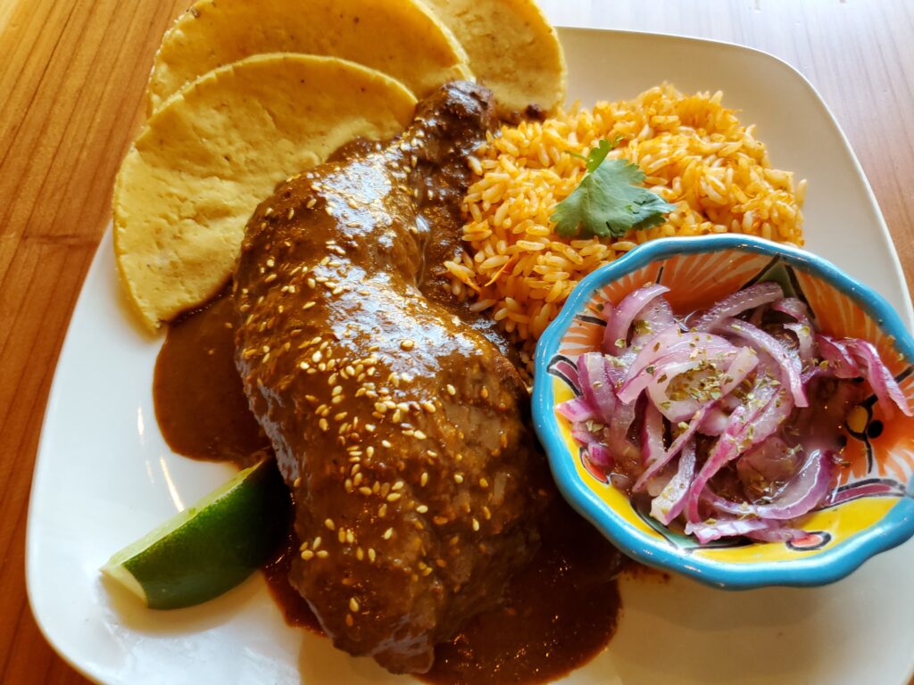mole smothered chicken, corn tortillas, rice, and pickled onions