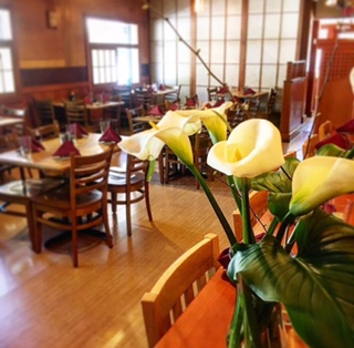 restaurant interior with dining table and a bouquet of calla lilies