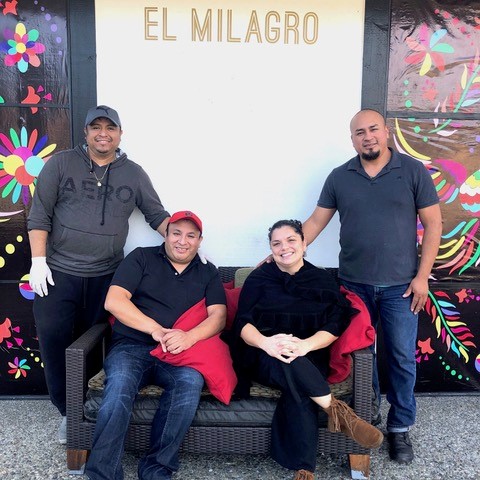 owners of el milagro posing for a picture outside