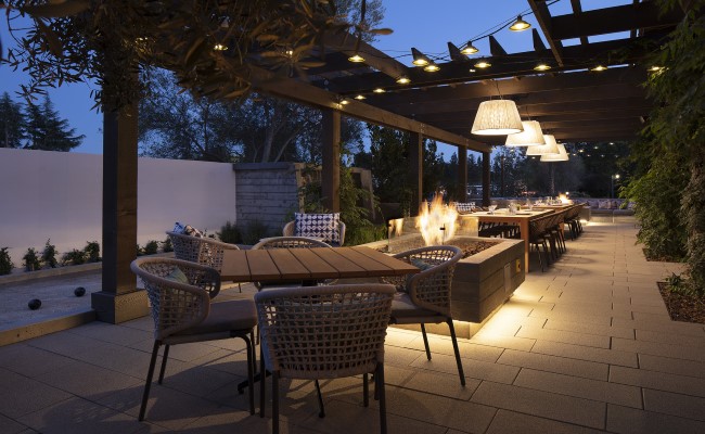 Wit and wisdom outdoor patio with dining table set, bistro lighting, and fire places