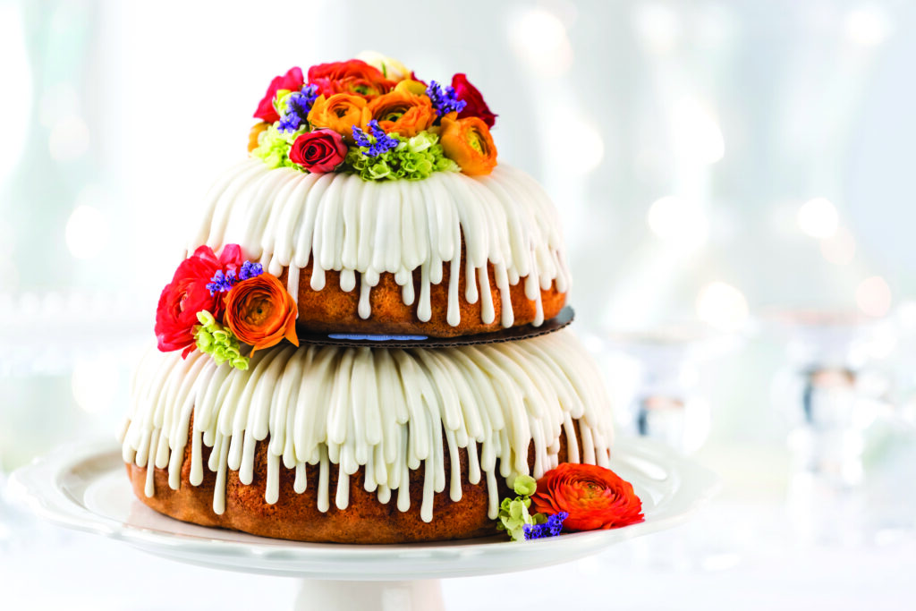 Nothing Bundt Cakes. bundt cake tower with icing and flower decor.