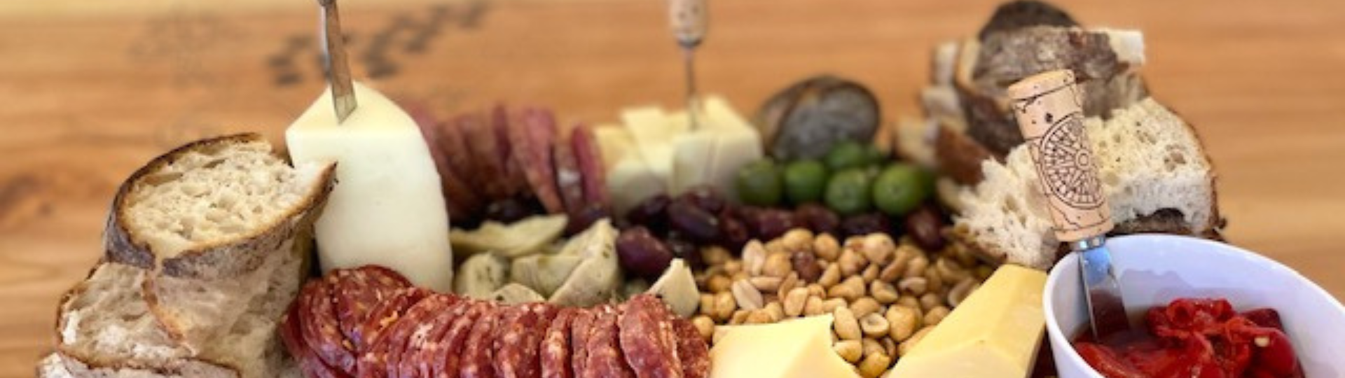 Vine and Barrel charcutier board with cheese, meats, nuts, bread, and jam.